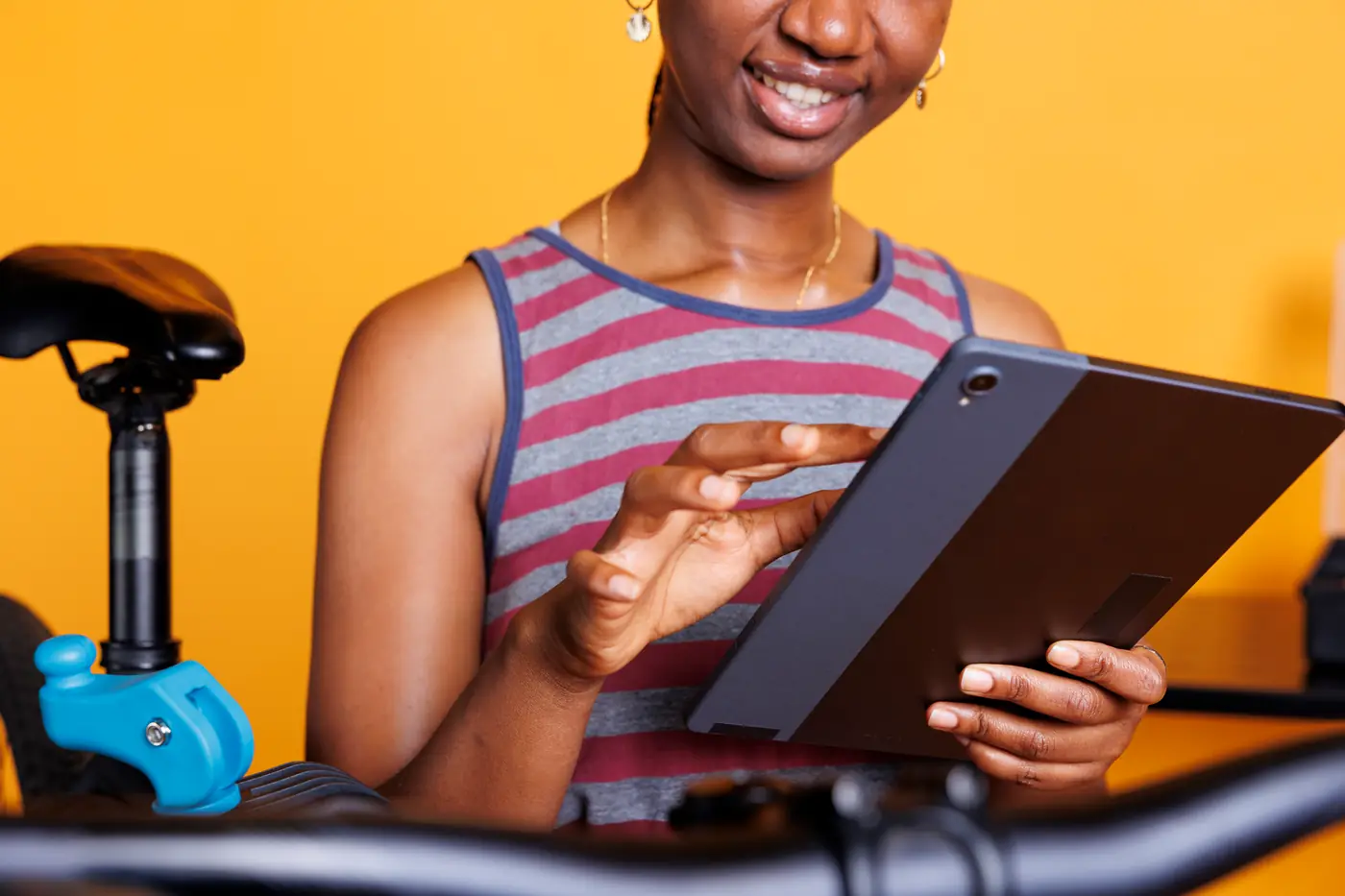 A woman looking something up on a tablet, holding it in one hand